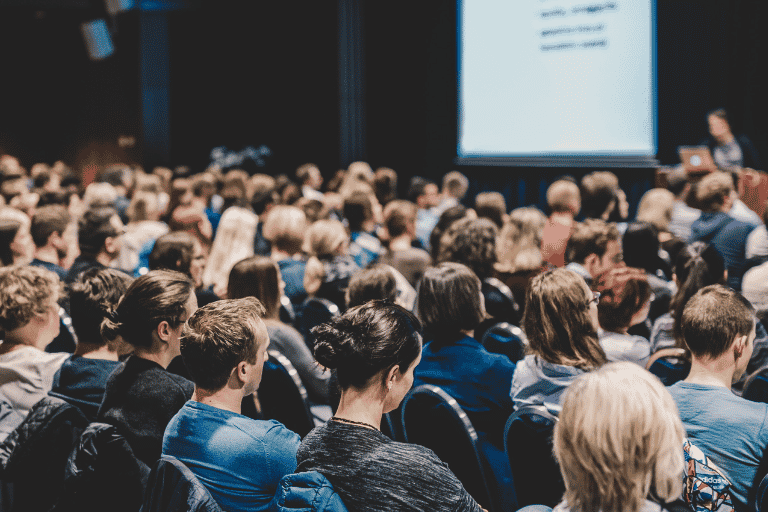 A crowd of people looking at a presentation
