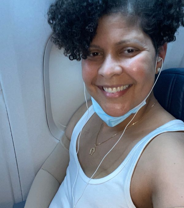 Amara Brown takes a selfie as she sits in her airplane seat.