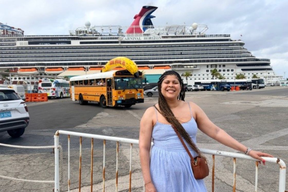 Amara Brown smiles as she waits to board the huge cruise ship behind her.
