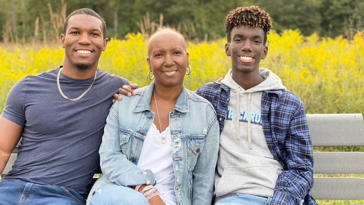 Stacey Kirksey sitting on a bench with her two sons.