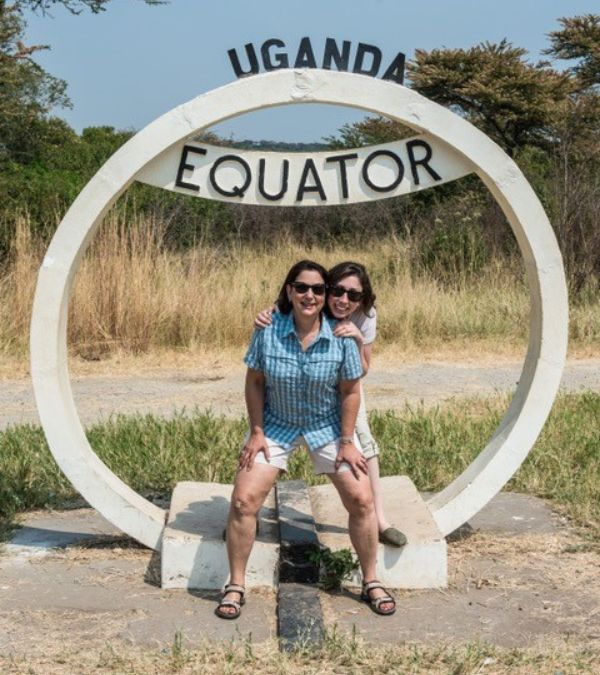 Nancy Poorvu and her daughter sit in the circular monument marking the equator in Uganda.