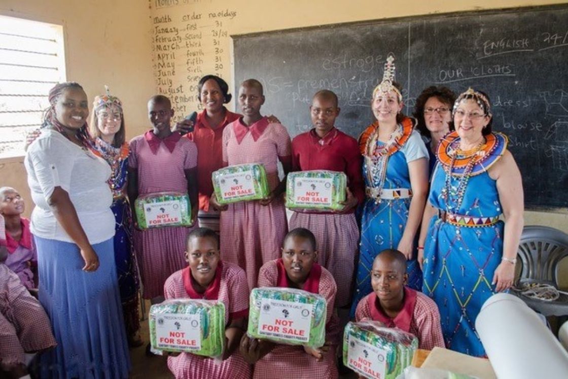 Nancy Poorvu wears brightly colored traditional clothing among her Maasai friends in a classroom.