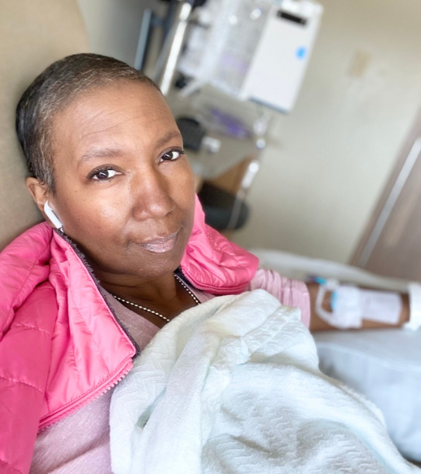 Stacey Kirksey looking at the camera while in an IV infusion chair.