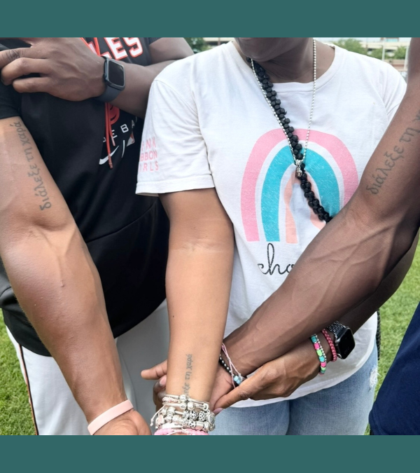 Stacey Kirksey and her sons display their matching tattoos on their forearms.