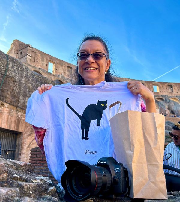 Tiernnee' Jefferis displays a cat t-shirt to honor the cats of the Coliseum behind her.