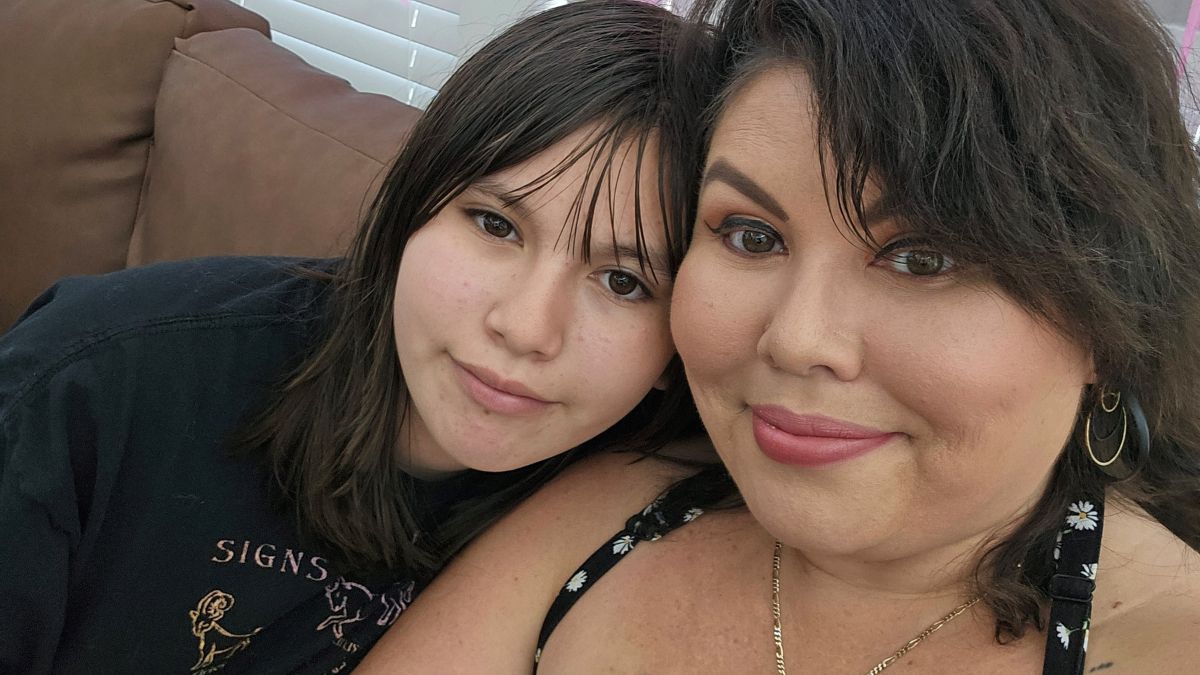 Deb Ontiveros and her daughter cuddle on the sofa.