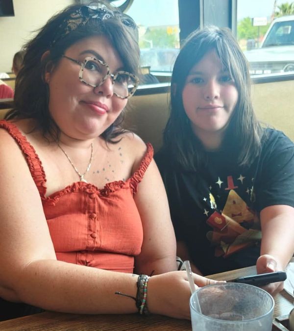 Deb Ontiveros and her daughter sit at a restaurant booth.