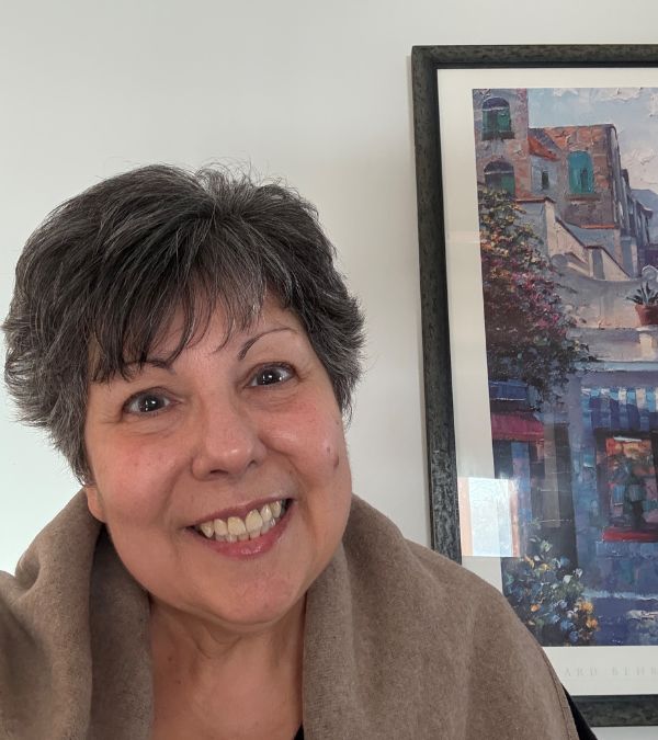 Marianne D'Alessandro stands proudly in front of her wall art.