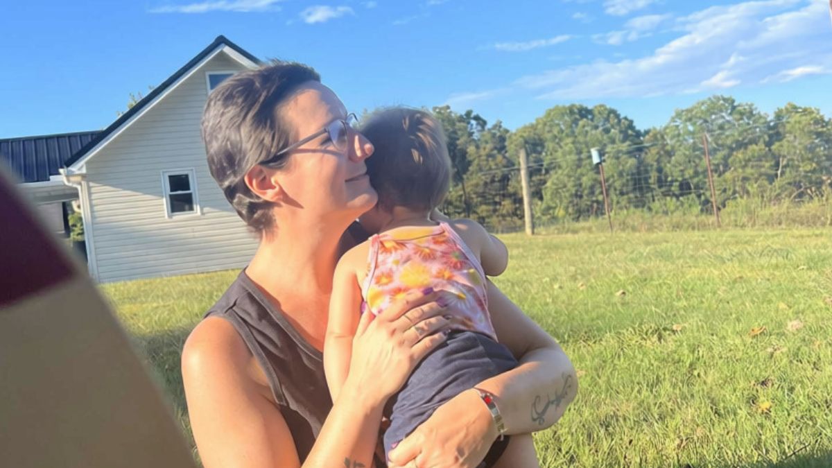 Ericka Toth pats her granddaughter's back as she carries her in their large backyard area.