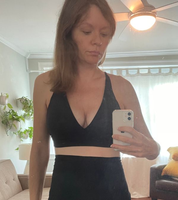 Kim Quick takes a last image of her breasts in a dark bra before the day of her mastectomy.