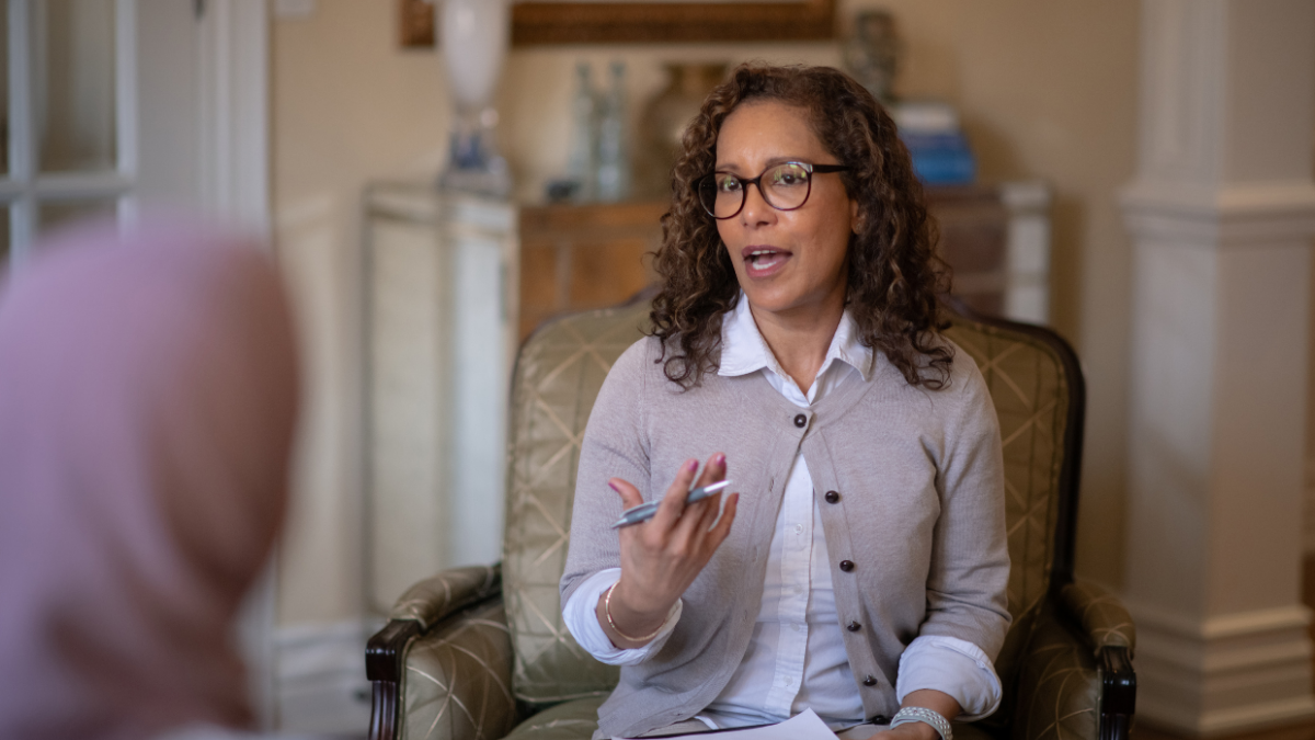 A therapist addresses a client in an office setting.