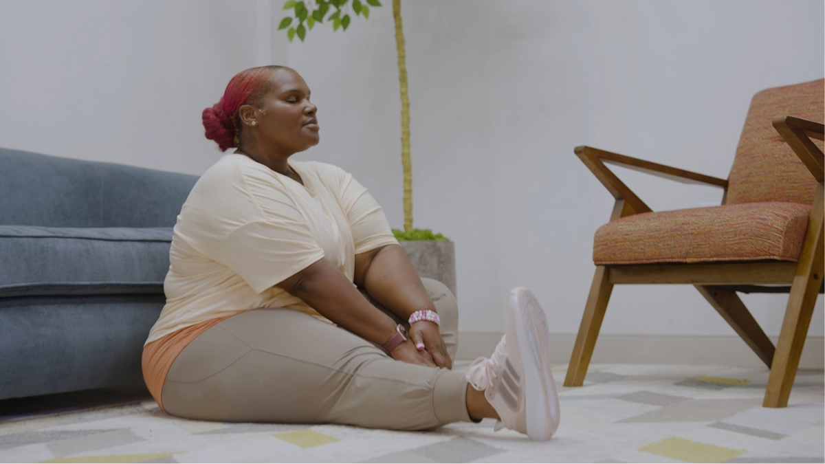 A woman gently stretching with a calm and peaceful facial expression.