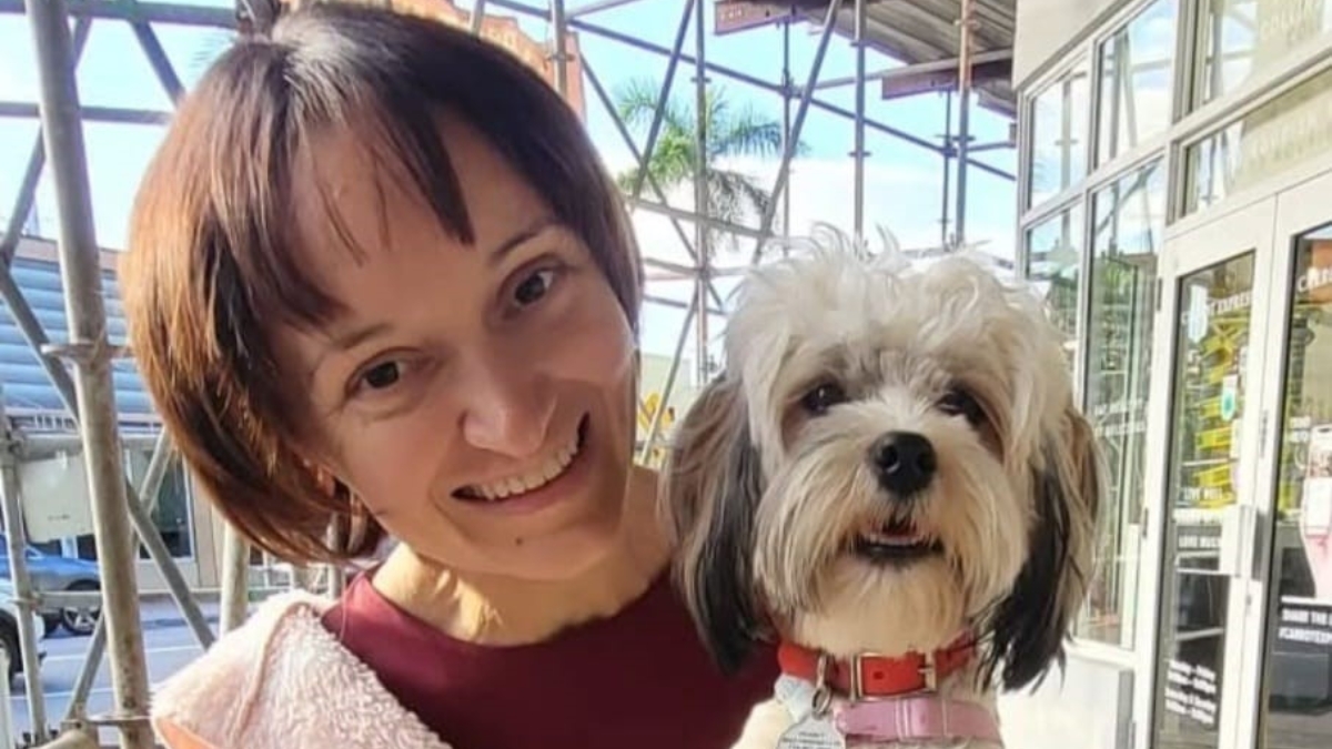 Florina Dragovic smiles widely as she holds her small dog Peanut.