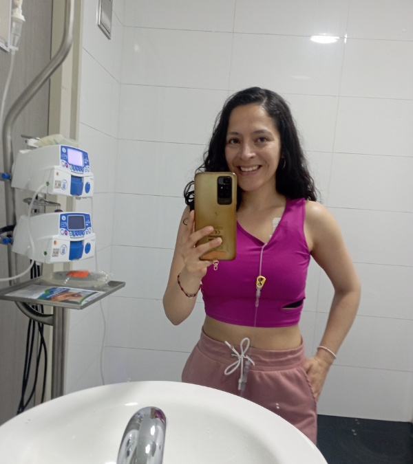 Gynna Quintero takes a selfie accompanied by her chemotherapy infusion machine.