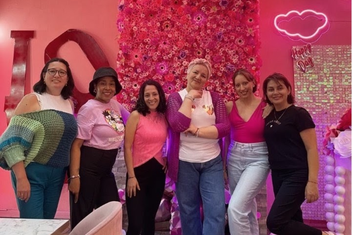 Gynna P. Quintero stands with her "cancer sisters" in front of a pink wall.