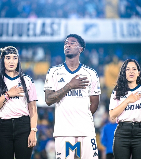 Gynna Quintero stands with a soccer player and another advocate with a hand placed over their heart.