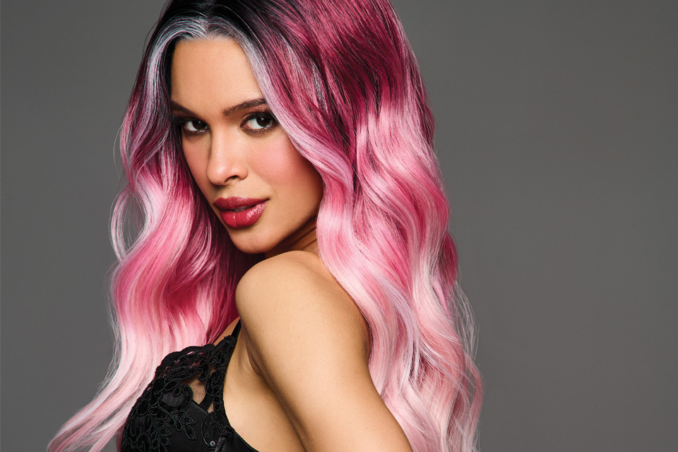 A Black woman wearing a long pink wig
