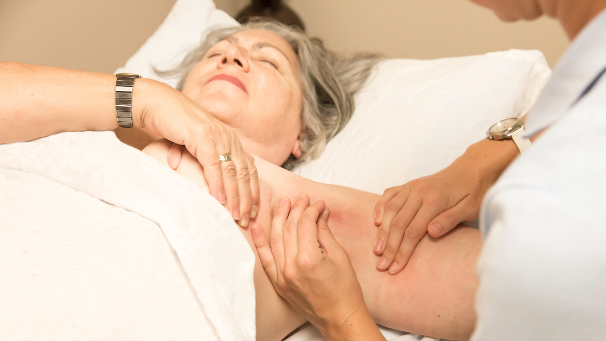 A woman receiving massage therapy to her shoulder.