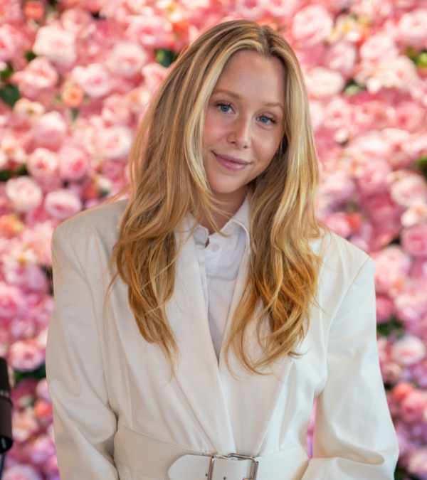 Miranda McKeon poses for a photograph in front of a flower backdropl