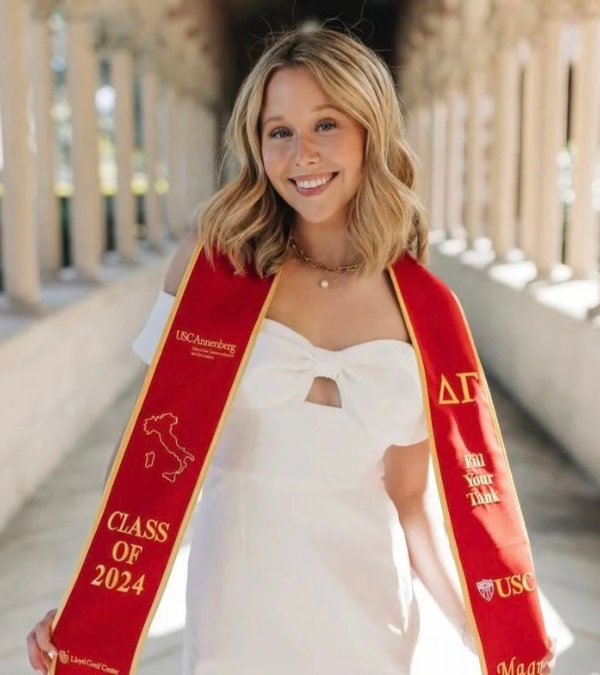 Miranda McKeon poses for a graduation photo wearing a white dress and red stole from her alma mater, University of Southern California.