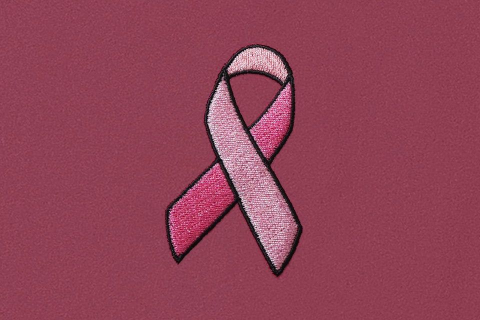 A pink embroidered breast cancer awareness ribbon