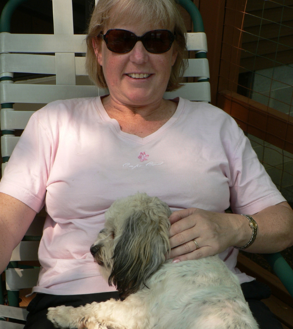 Lauren Bolen relaxes outside with the family dog resting on her lap.