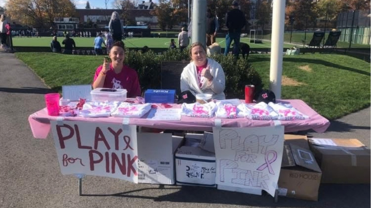 Student athletes at Tufts University sit at a table at the Play for Pink fundraiser.