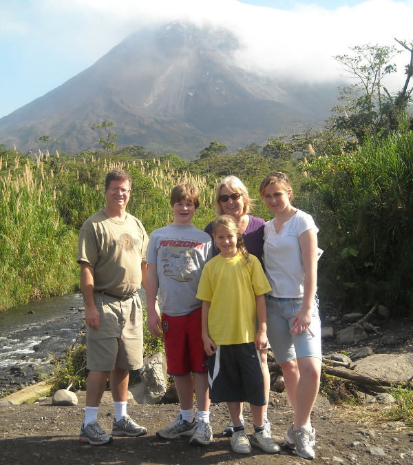 The Bolen family poses together in front of a mountain backdrop on a family trip.