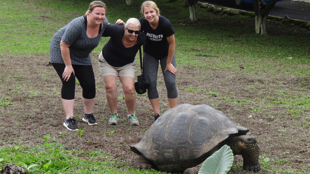 Lilly Bolen, her mother, Lauren, and her sister, Kathryn, pose in front of a massive tortoise during their trip to Galapagos Islands.