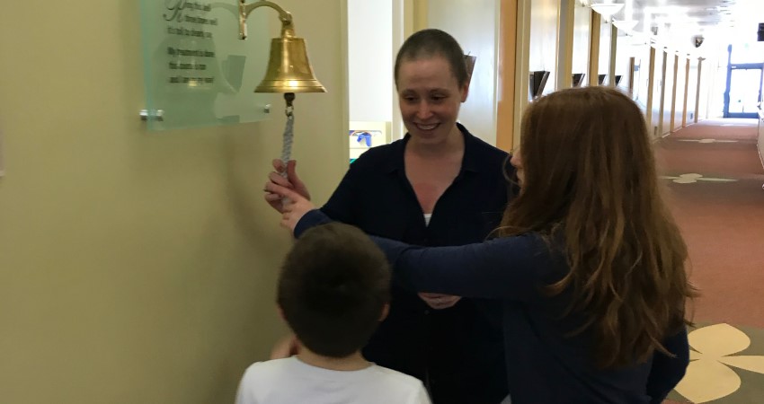 Jennifer and family ring bell to commemorate the end of treatment.