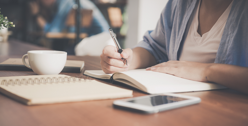Woman writing with pen and paper